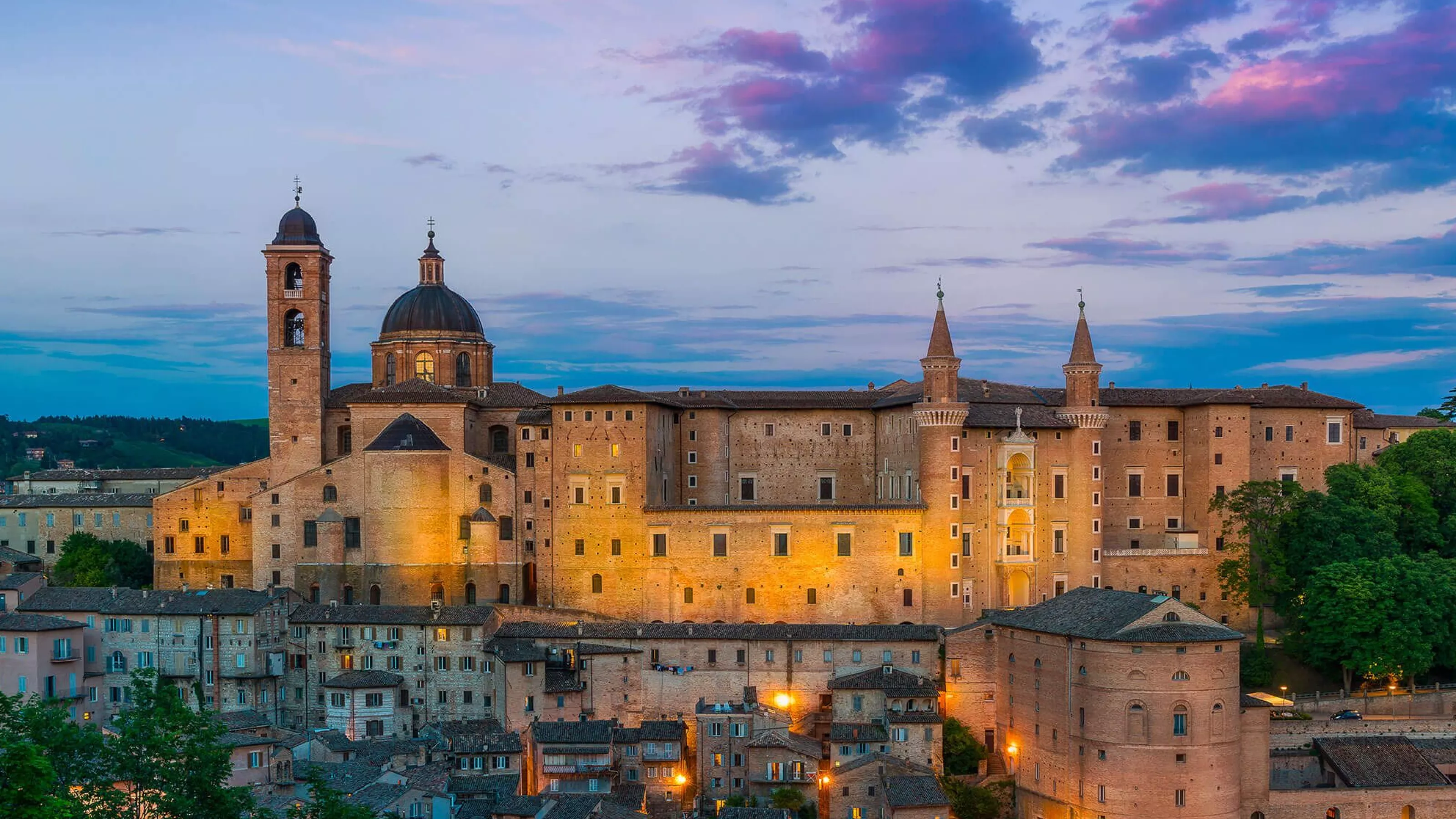 Il Palazzo Ducale di Urbino con i suoi torricini, illuminato al tramonto